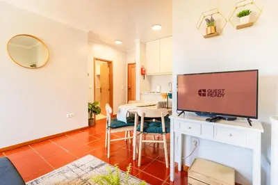 a living room with a dining room table with a flat screen tv at GuestReady - Madeiran peaceful nook in Porto Moniz