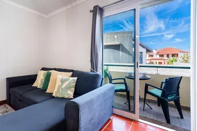 a living room with a couch and a balcony at GuestReady - Madeiran peaceful nook in Porto Moniz