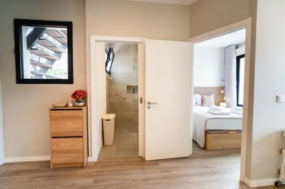 a bathroom with a shower and a bedroom with a bed at GuestRedy - A Modern Stay in Machico in Machico