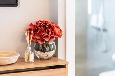 a vase filled with red roses sitting on a table at GuestRedy - A Modern Stay in Machico in Machico