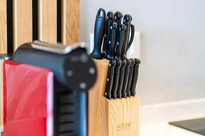 a knife block with a bunch of kitchen utensils at GuestRedy - A Modern Stay in Machico in Machico