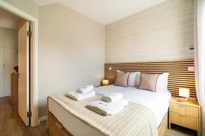a bedroom with a bed with towels on it at GuestRedy - A Modern Stay in Machico in Machico
