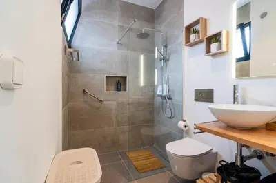 a bathroom with a shower with a toilet and a sink at GuestRedy - A Modern Stay in Machico in Machico