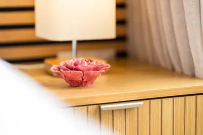 a pink flower in a bowl on a table at GuestRedy - A Modern Stay in Machico in Machico