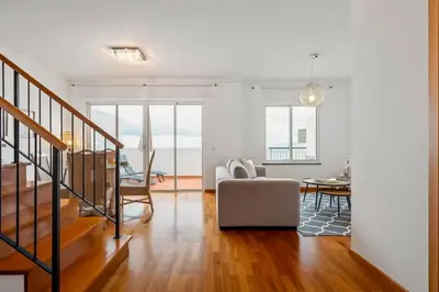 a living room with a couch and a table at Modern Suburban Haven in Caniço
