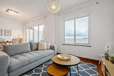 a living room with a couch and a table at Modern Suburban Haven in Caniço