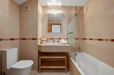 a bathroom with a toilet and a sink and a tub at Modern Suburban Haven in Caniço