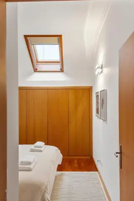 a bedroom with a bed and a window on the ceiling at Modern Suburban Haven in Caniço