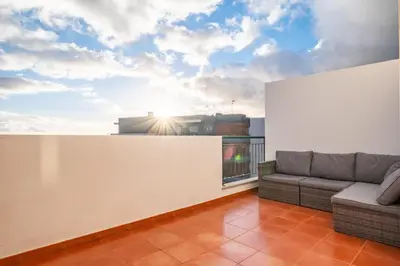 a living room with a couch and a balcony at Modern Suburban Haven in Caniço