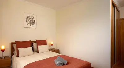 a bedroom with a bed and two candles on the table at Calheta, Sun, Sea & Pool in Calheta