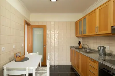 a kitchen with a sink and a white table at Calheta, Sun, Sea & Pool in Calheta