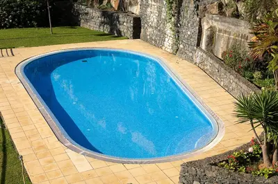 a large blue swimming pool in a yard at Calheta, Sun, Sea & Pool in Calheta
