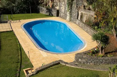 a large blue swimming pool in a yard at Calheta, Sun, Sea & Pool in Calheta
