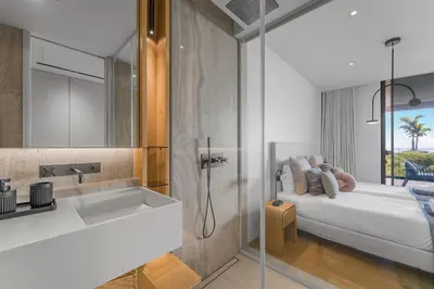 a bathroom with a shower and a sink and a bed at Savoy Luxury Residence Apartment in Funchal