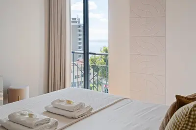 a bedroom with a bed with towels and a window at Fórum Glam 5B by Homie in Funchal