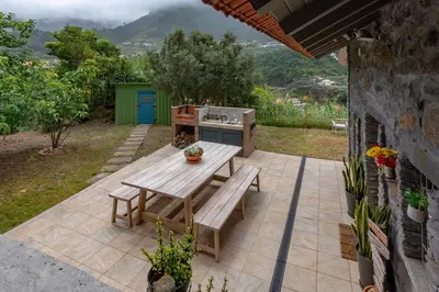 a patio with a picnic table and a stove at The Yellow Cottage Nature House São Vicente Madeira Island in São Vicente