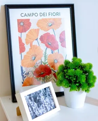 a picture of flowers in a picture frame next to a plant at The Yellow Cottage Nature House São Vicente Madeira Island in São Vicente