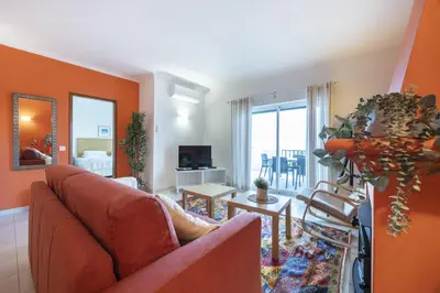 a living room with orange walls and a couch at CoolHouses Algarve Luz, Ramalhete in Luz