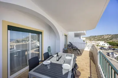 a balcony with a table and a view of the ocean at CoolHouses Algarve Luz, Ramalhete in Luz
