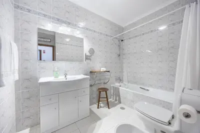 a white bathroom with a sink and a tub and a toilet at CoolHouses Algarve Luz, Ramalhete in Luz