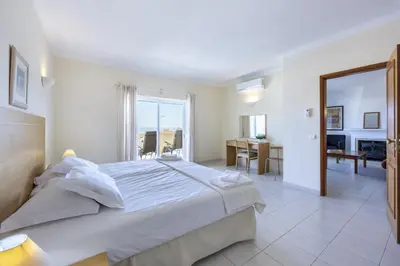 a bedroom with a large bed with a view of a room at CoolHouses Algarve Luz, Ramalhete in Luz