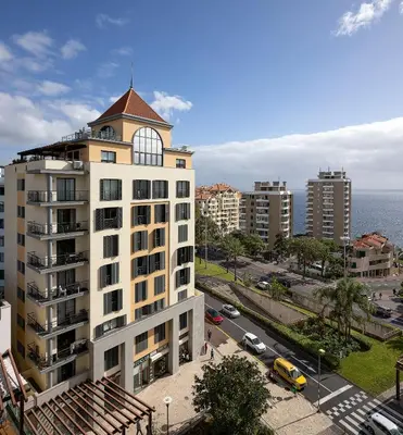 a tall white building with a tower on top of it at JOY Forum I in Funchal