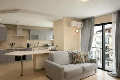 a kitchen and living room with a couch and a table at JOY Forum I in Funchal