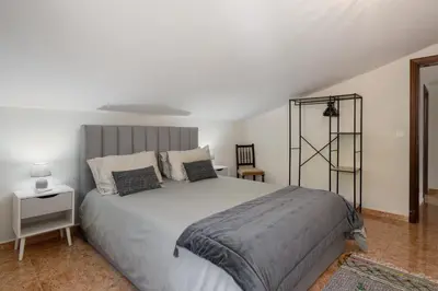 a white bedroom with a large bed and a table at OurMadeira - Ponta do Sol SeaView in Relógio do Poiso