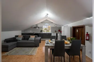 a living room with a couch and a table with chairs at OurMadeira - Ponta do Sol SeaView in Relógio do Poiso