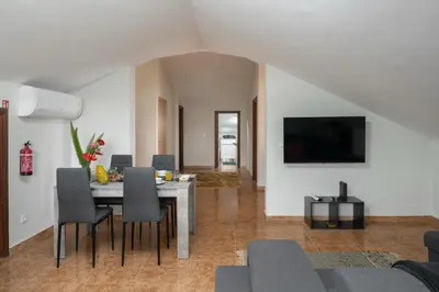 a living room with a table with chairs and a tv at OurMadeira - Ponta do Sol SeaView in Relógio do Poiso