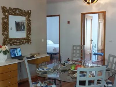 a dining room with a table and a mirror at Monumental Sur Mer in Funchal