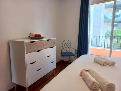 a bedroom with a bed and a dresser and a window at Monumental Sur Mer in Funchal