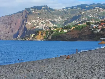 a beach with a view of the water and mountains at Monumental Sur Mer in Funchal