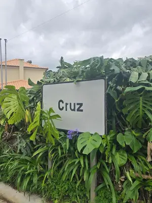 a sign for a club in some plants at Casa da Cruz in Porto da Cruz