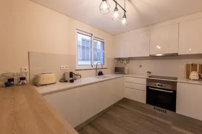 a large kitchen with white cabinets and a window at City Center Apartment with Parking - 2stay in Funchal