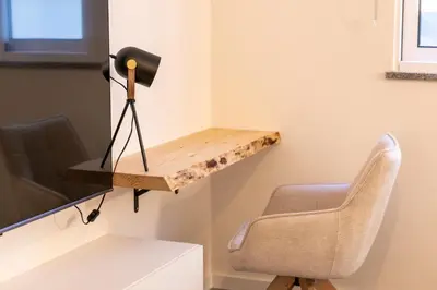 a desk in a room with a chair and a television at City Center Apartment with Parking - 2stay in Funchal