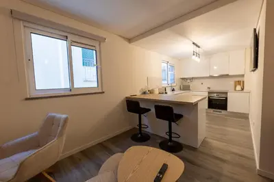 a kitchen with a counter and two chairs and a table at City Center Apartment with Parking - 2stay in Funchal