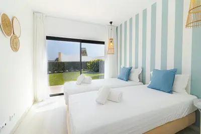 two beds in a room with a window at Villa Infante in Sagres