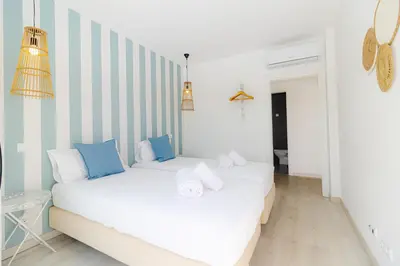 two beds in a room with blue and white stripes at Villa Infante in Sagres