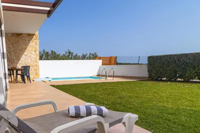 a patio with a table and chairs in a yard at Villa Infante in Sagres