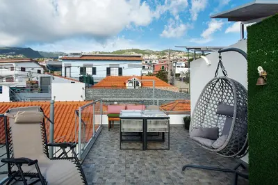 a patio with a table and chairs on a balcony at Sissi Lanço View 7 in Funchal
