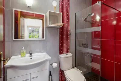 a bathroom with a toilet and a sink and a shower at Villa Graycis House by Villa Plus in Arco da Calheta