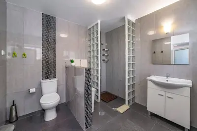 a bathroom with a toilet and a sink at Villa Graycis House by Villa Plus in Arco da Calheta