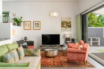 a living room with a couch and chairs and a tv at Villa Graycis House by Villa Plus in Arco da Calheta