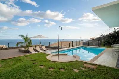 a swimming pool with a view of the ocean at Calma Retreat - Pool & Lodge in Câmara de Lobos