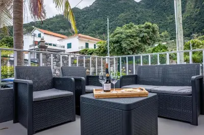 a patio with a table with a bottle of wine at Solar do Pico Apartment in Ponta Delgada