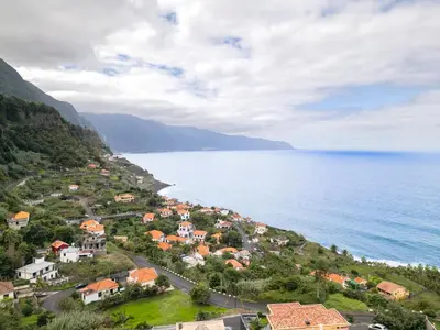 a town on a hill next to the ocean at Solar do Pico Apartment in Ponta Delgada