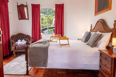 a bedroom with a bed with a table and a chair at Solar do Pico Apartment in Ponta Delgada