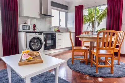 a kitchen and dining room with a table and chairs at Solar do Pico Apartment in Ponta Delgada