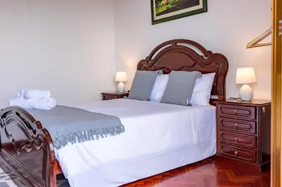 a bedroom with a bed and a dresser with two lamps at Solar do Pico Studio in Ponta Delgada